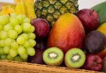 red apple fruit beside green apple and yellow fruit on brown woven basket