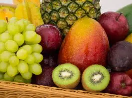 red apple fruit beside green apple and yellow fruit on brown woven basket