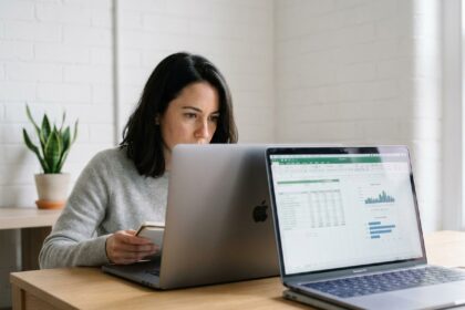 Femme comparant deux modèles de MacBook Pro côte à côte sur un bureau en bois