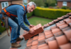 Combien coûte la rénovation d’une toiture de 100 m² avec des tuiles en terre cuite ? Couvreur middleaged posant avec tuiles en terre cuite sur toit en rénovation