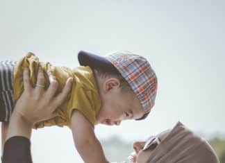 woman holding boy during daytime