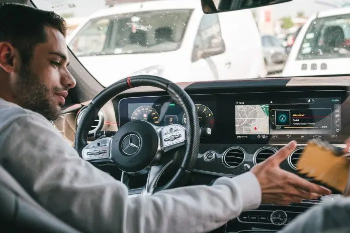 man in gray sweater driving car