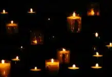 lit yellow candles in the dark