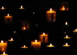 lit yellow candles in the dark