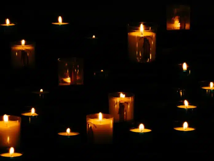 lit yellow candles in the dark